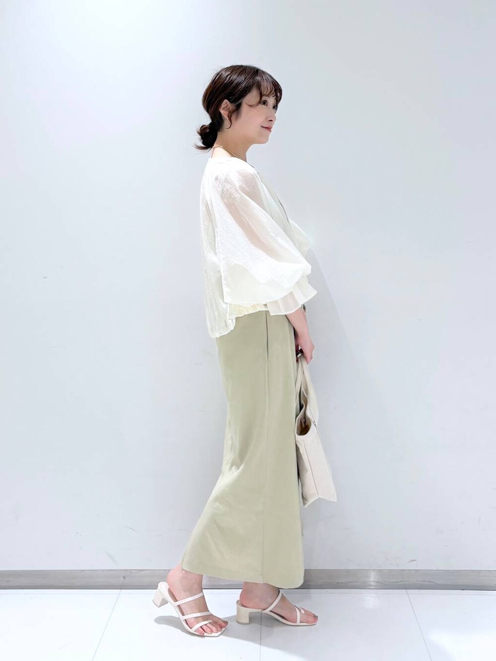ホワイト系のTシャツ/カットソー、ホワイト系のショルダーバッグ、ホワイト系のサンダルを着用したレディースの春コーディネートの4枚目の写真
