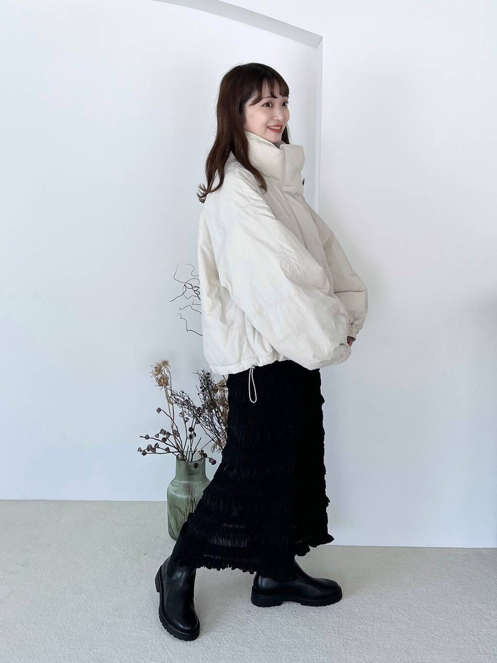 ブラック系のブーツ、ブラック系のスカート、ゴールド系のピアス(両耳用)を着用したレディースの夏コーディネートの2枚目の写真