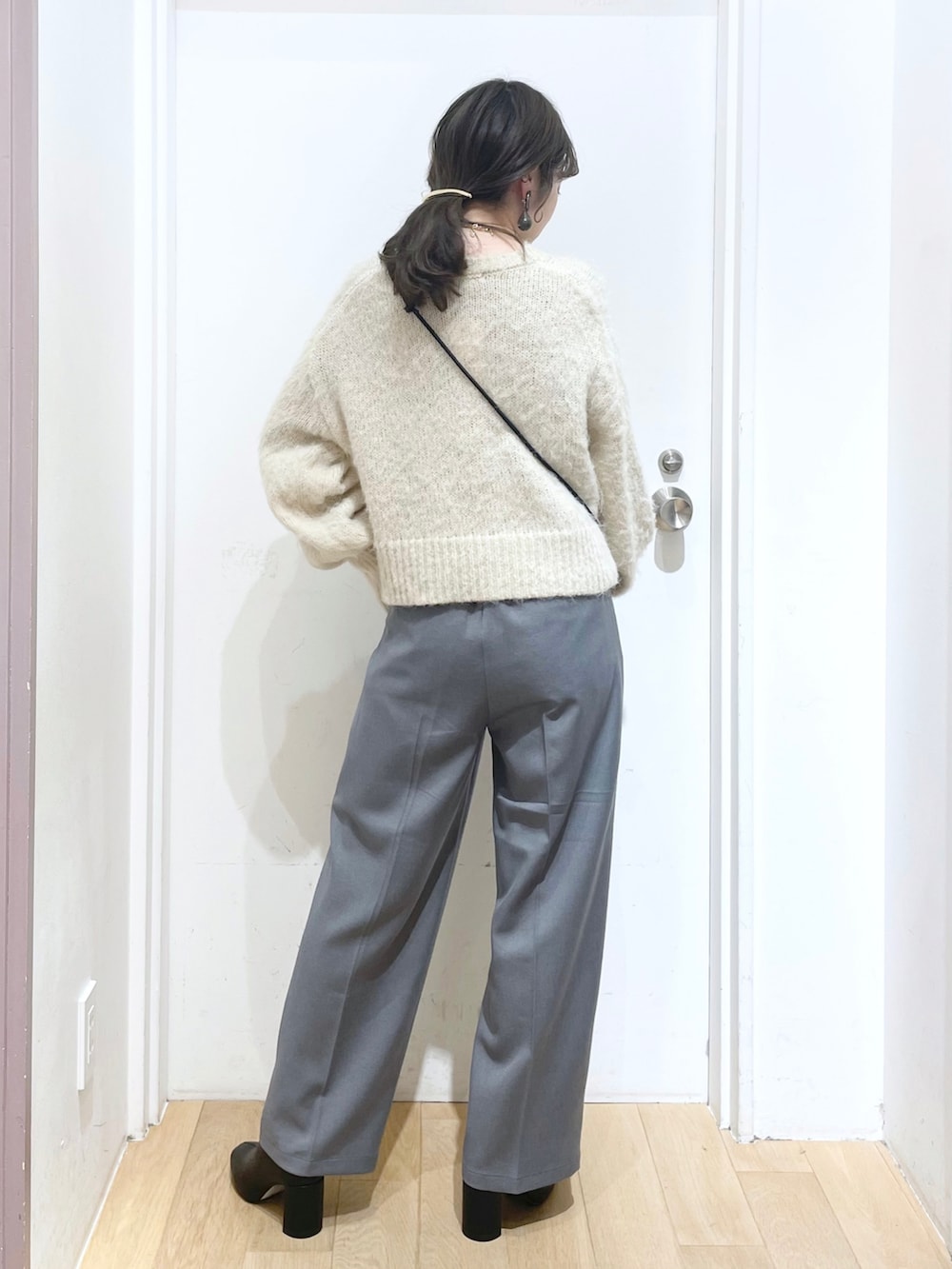 グレー系のその他パンツ、ブラック系のブーツ、ブラック系のショルダーバッグを着用したレディースの冬コーディネートの2枚目の写真