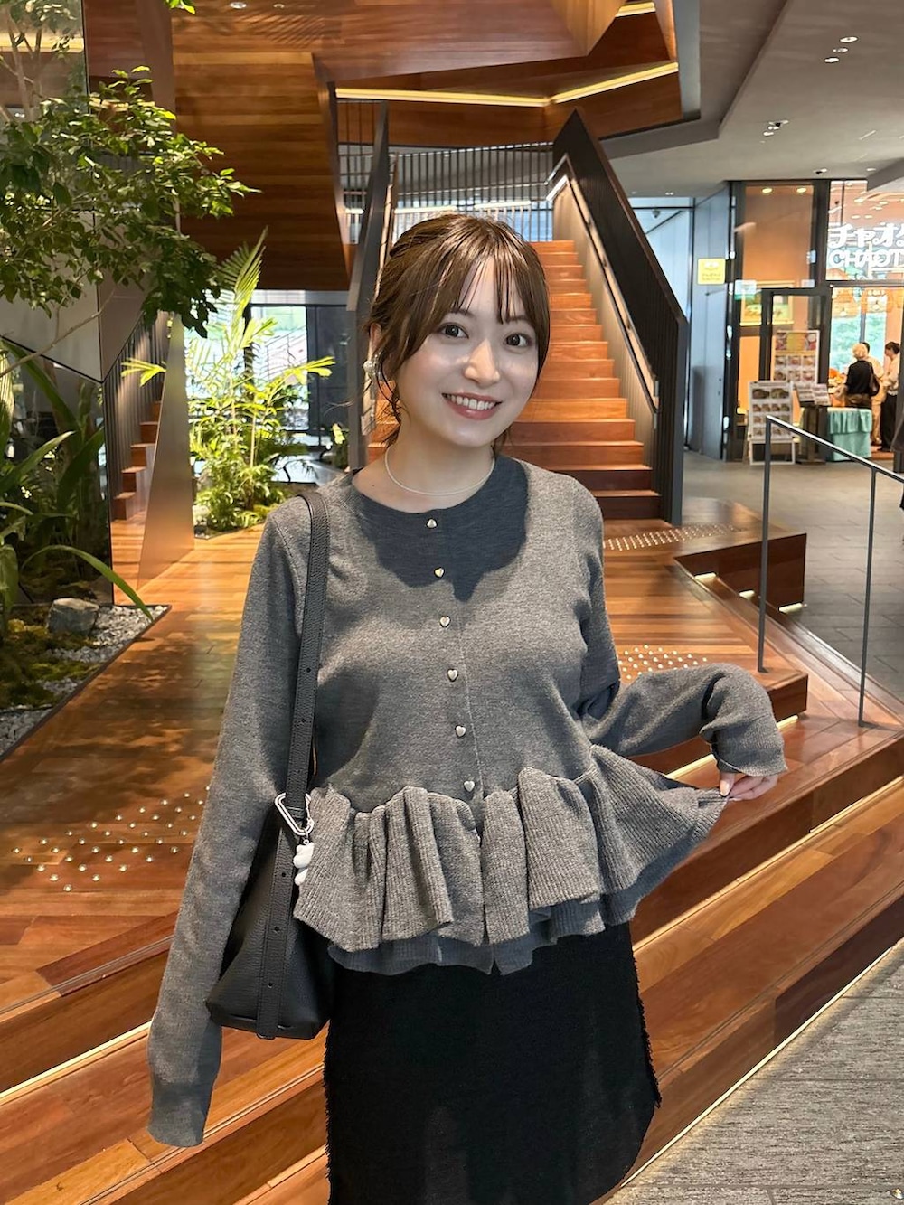 ブラック系のブーツ、ホワイト系のネックレスを着用したレディースの秋コーディネートの2枚目の写真