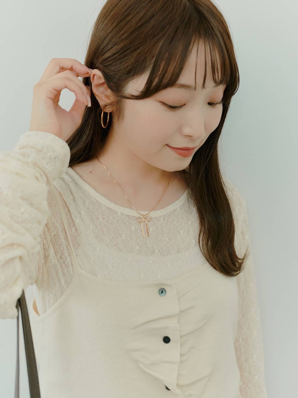 ブラウン系のボストンバッグ、ホワイト系のキャミソール、ホワイト系のTシャツ/カットソーを着用したレディースの秋コーディネートの3枚目の写真