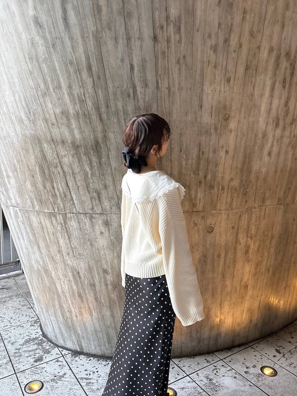 ブラック系のスカート、ブラック系のパンプス、ホワイト系のカーディガン/ボレロを着用したレディースの冬コーディネートの6枚目の写真