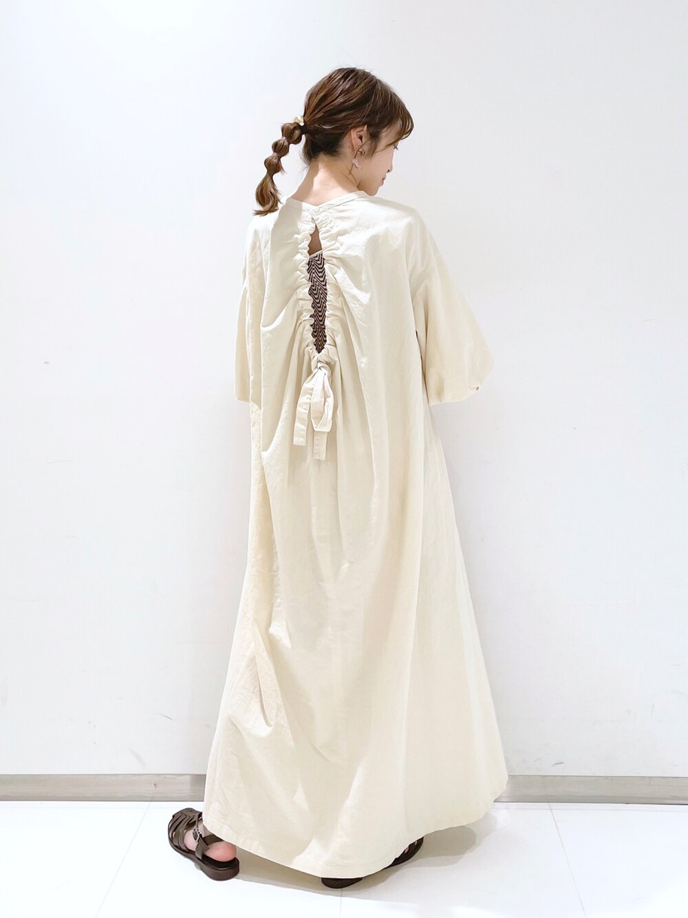 ブラウン系のサンダル、ホワイト系のワンピースを着用したレディースの春コーディネートの2枚目の写真