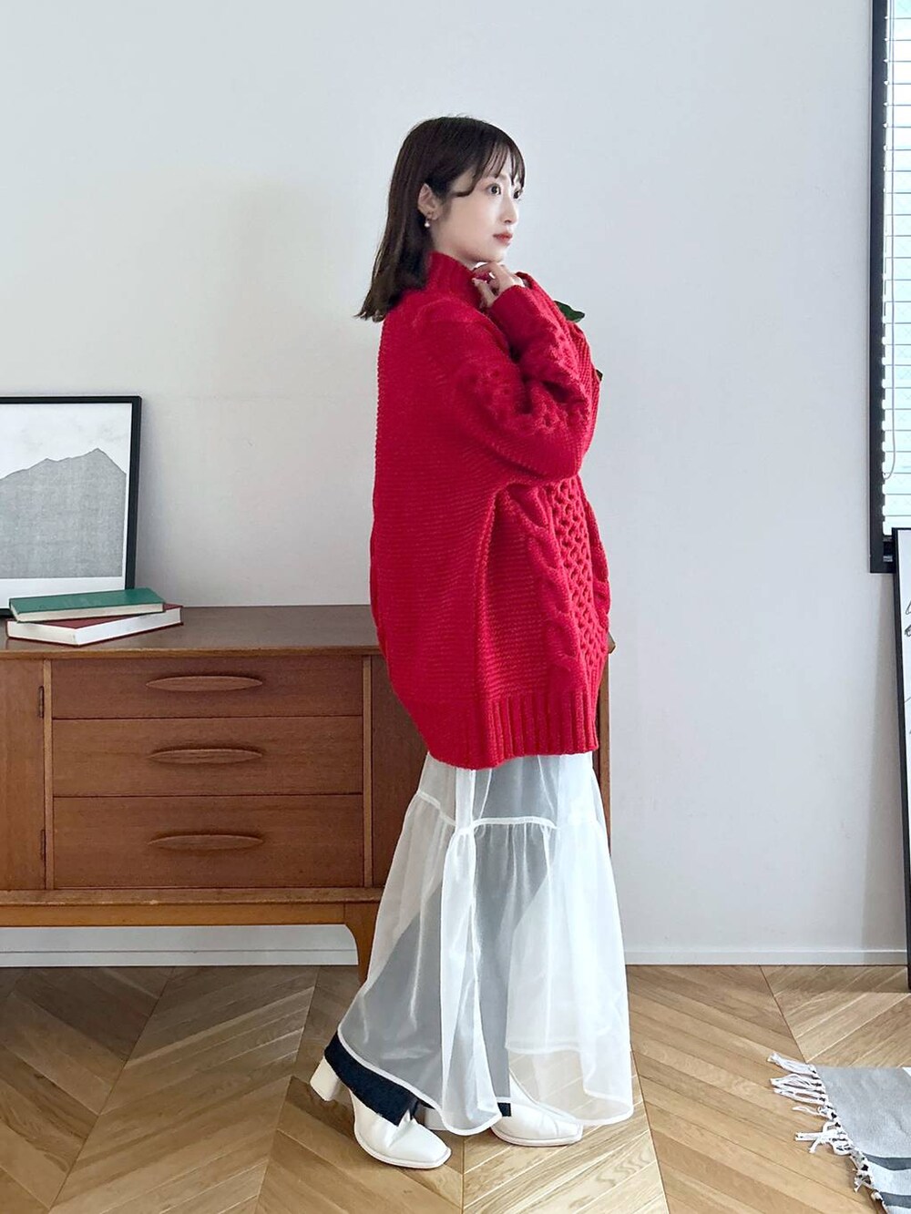 ブルー系のデニムパンツ、ホワイト系のパンプス、ホワイト系のスカートを着用したレディースの秋コーディネートの4枚目の写真