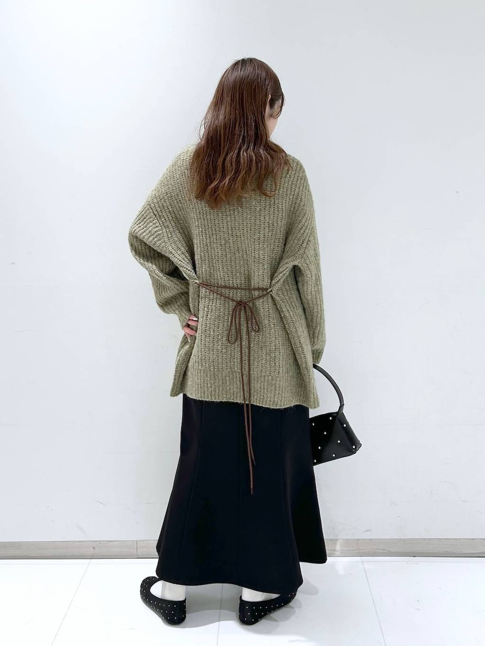 ホワイト系のタンクトップ、ブラック系のバレエシューズ、ブラック系のスカートを着用したレディースの秋コーディネートの5枚目の写真