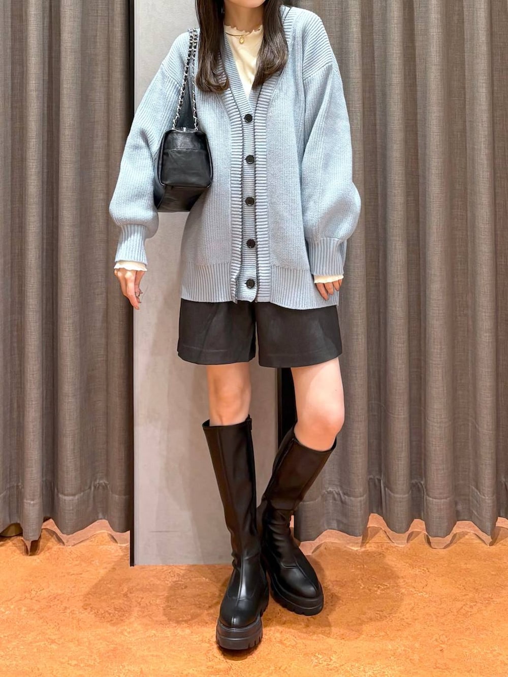 ブルー系のカーディガン/ボレロ、グレー系のその他パンツ、ブラック系のブーツを着用したレディースの冬コーディネートの3枚目の写真