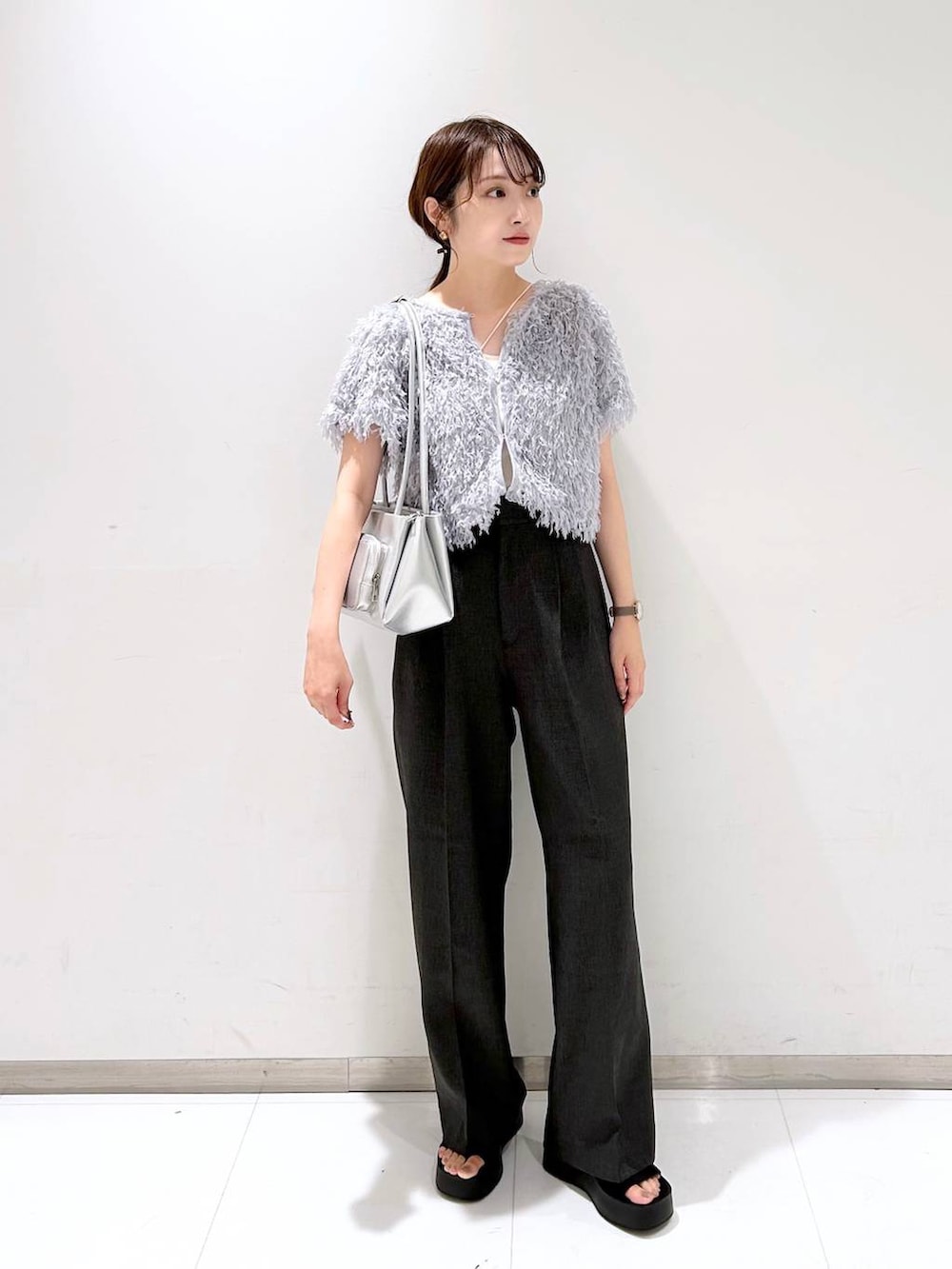 ブラック系のサンダル、ホワイト系のキャミソール、グレー系のスラックスを着用したレディースの夏コーディネートの3枚目の写真