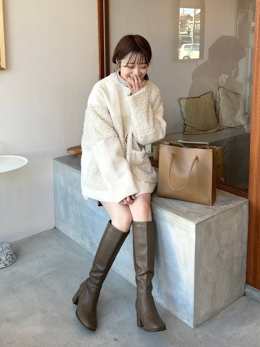 ホワイト系のブルゾンを着用したレディースの冬コーディネートの2枚目の写真