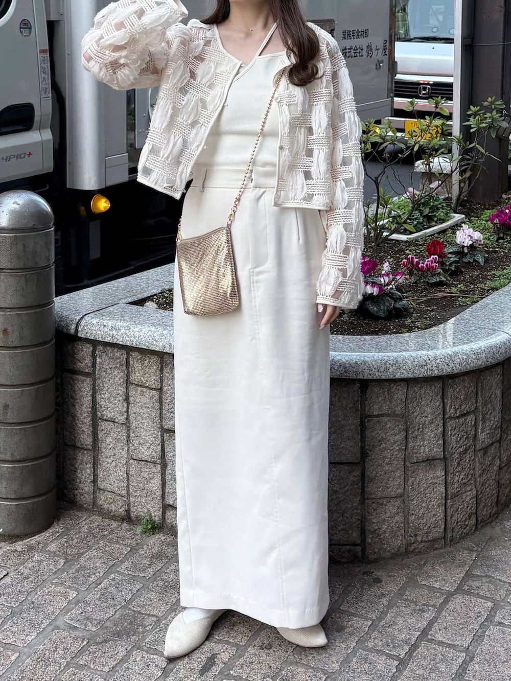 ゴールド系のショルダーバッグ、ホワイト系のパンプスを着用したレディースの春コーディネートの6枚目の写真