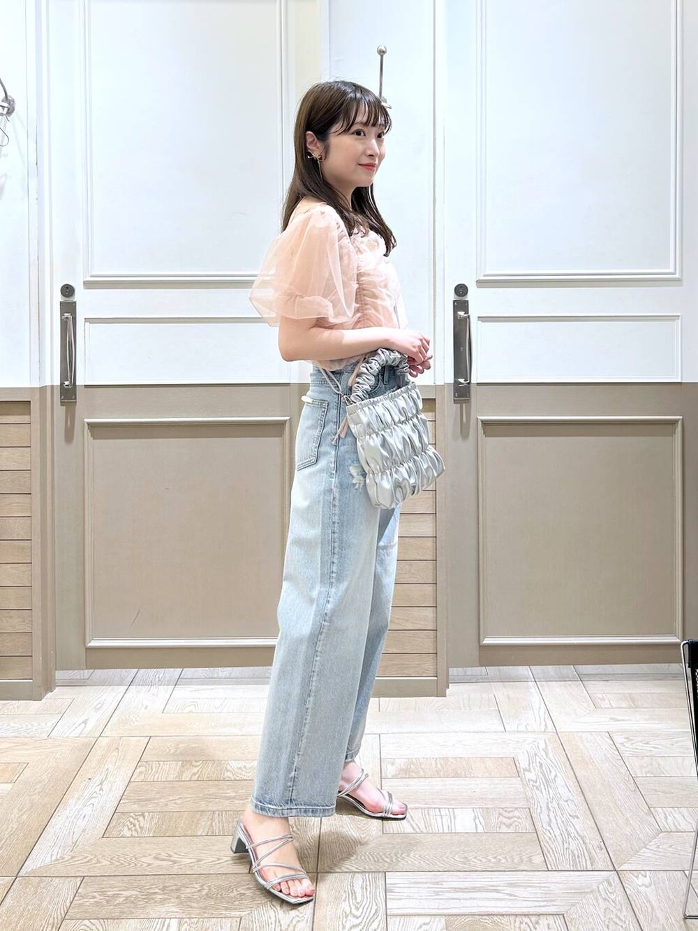 シルバー系のサンダル、ベージュ系のTシャツ/カットソー、ブルー系のデニムパンツを着用したレディースの春コーディネートの3枚目の写真