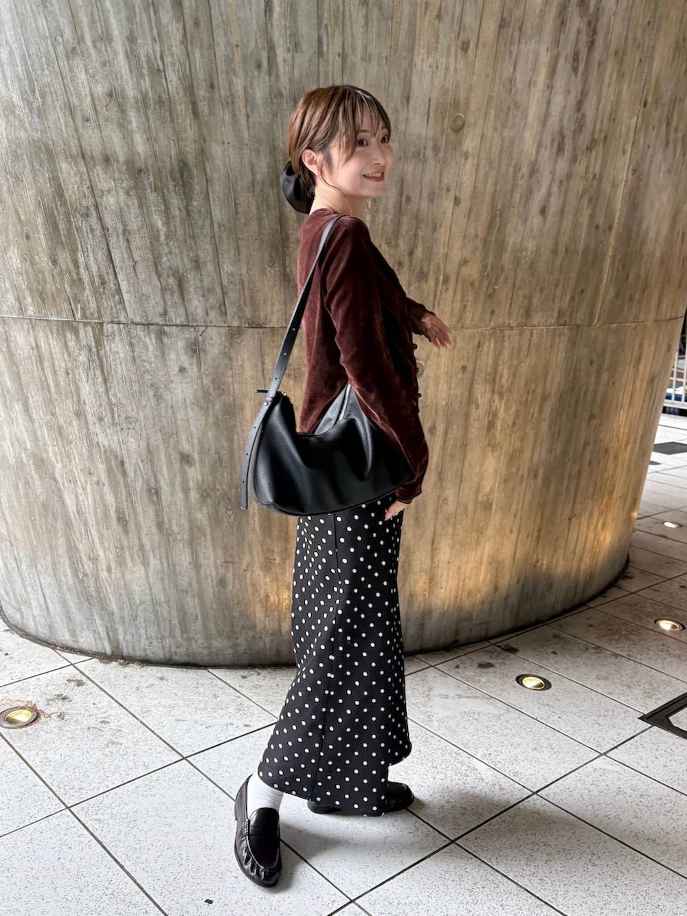 ブラウン系のTシャツ/カットソー、ブラック系のスカート、ブラウン系のローファーを着用したレディースの秋コーディネートの2枚目の写真