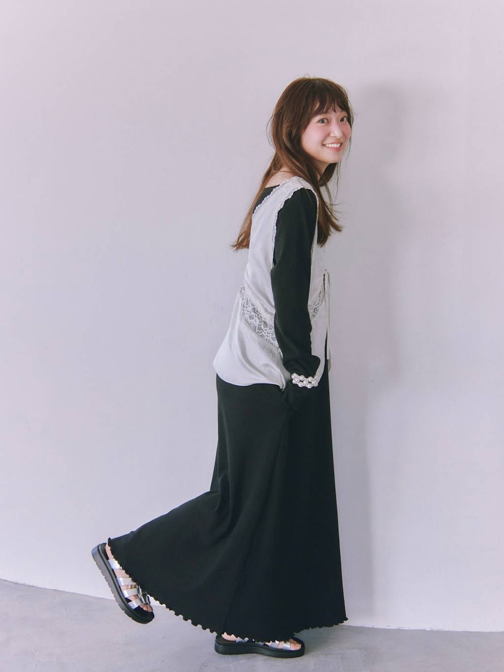 シルバー系のサンダル、ホワイト系のベストを着用したレディースの春コーディネートの2枚目の写真