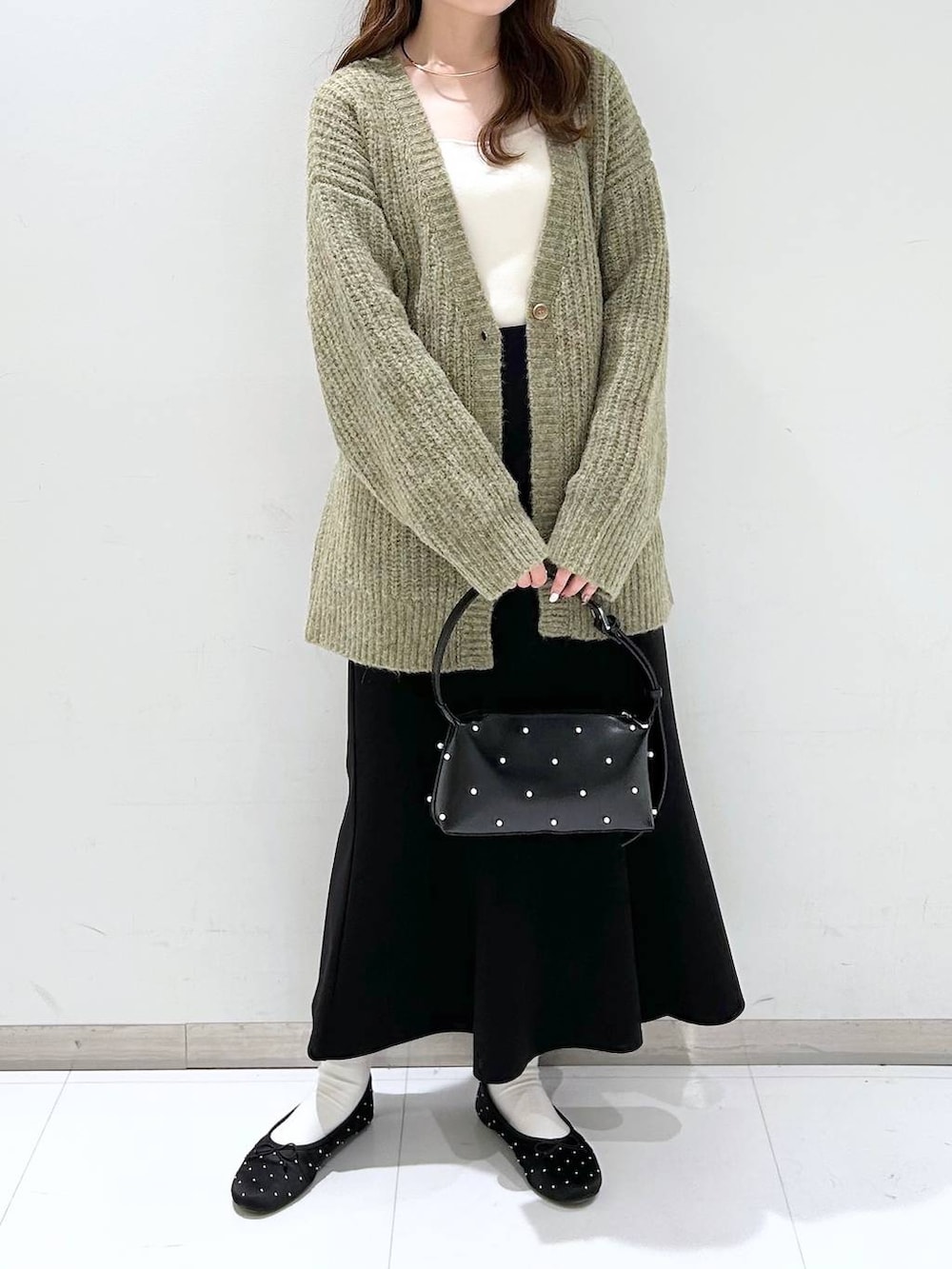 ホワイト系のタンクトップ、ブラック系のバレエシューズ、ブラック系のスカートを着用したレディースの秋コーディネートの3枚目の写真