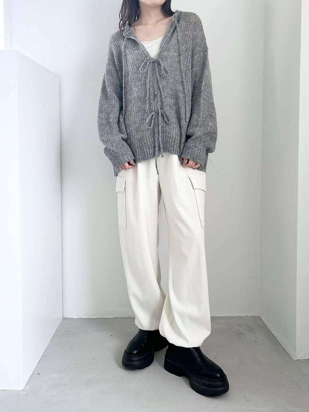 ホワイト系のキャミソール、ブラック系のブーツ、ホワイト系のカーゴパンツを着用したレディースの冬コーディネートの2枚目の写真