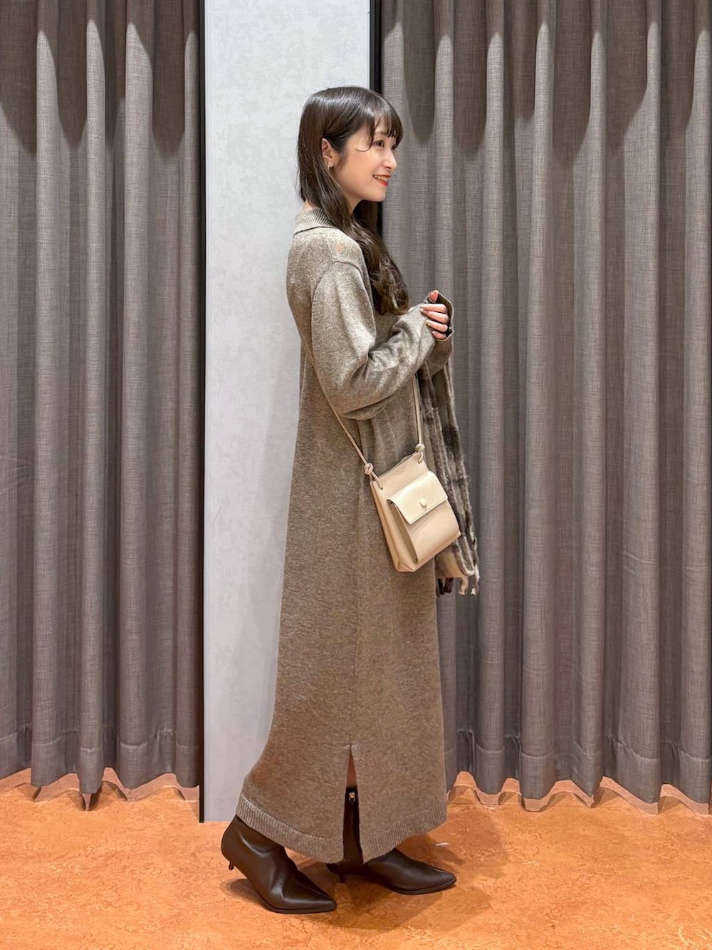 ホワイト系のその他アウター、ブラウン系のブーツ、ブラウン系のワンピースを着用したレディースの秋コーディネートの5枚目の写真