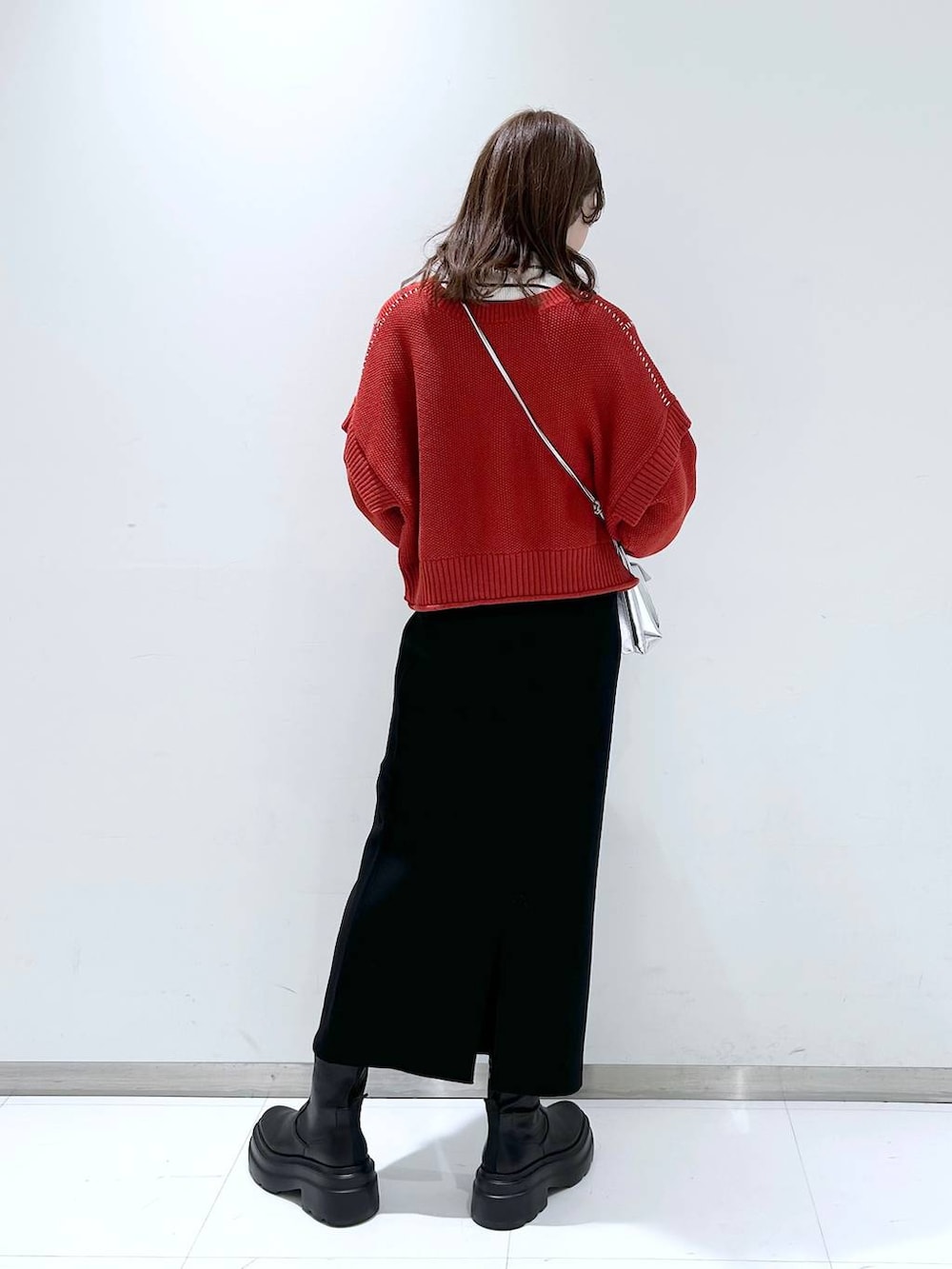 シルバー系のショルダーバッグ、グレー系のニット/セーター、レッド系のTシャツ/カットソーを着用したレディースの秋コーディネートの4枚目の写真