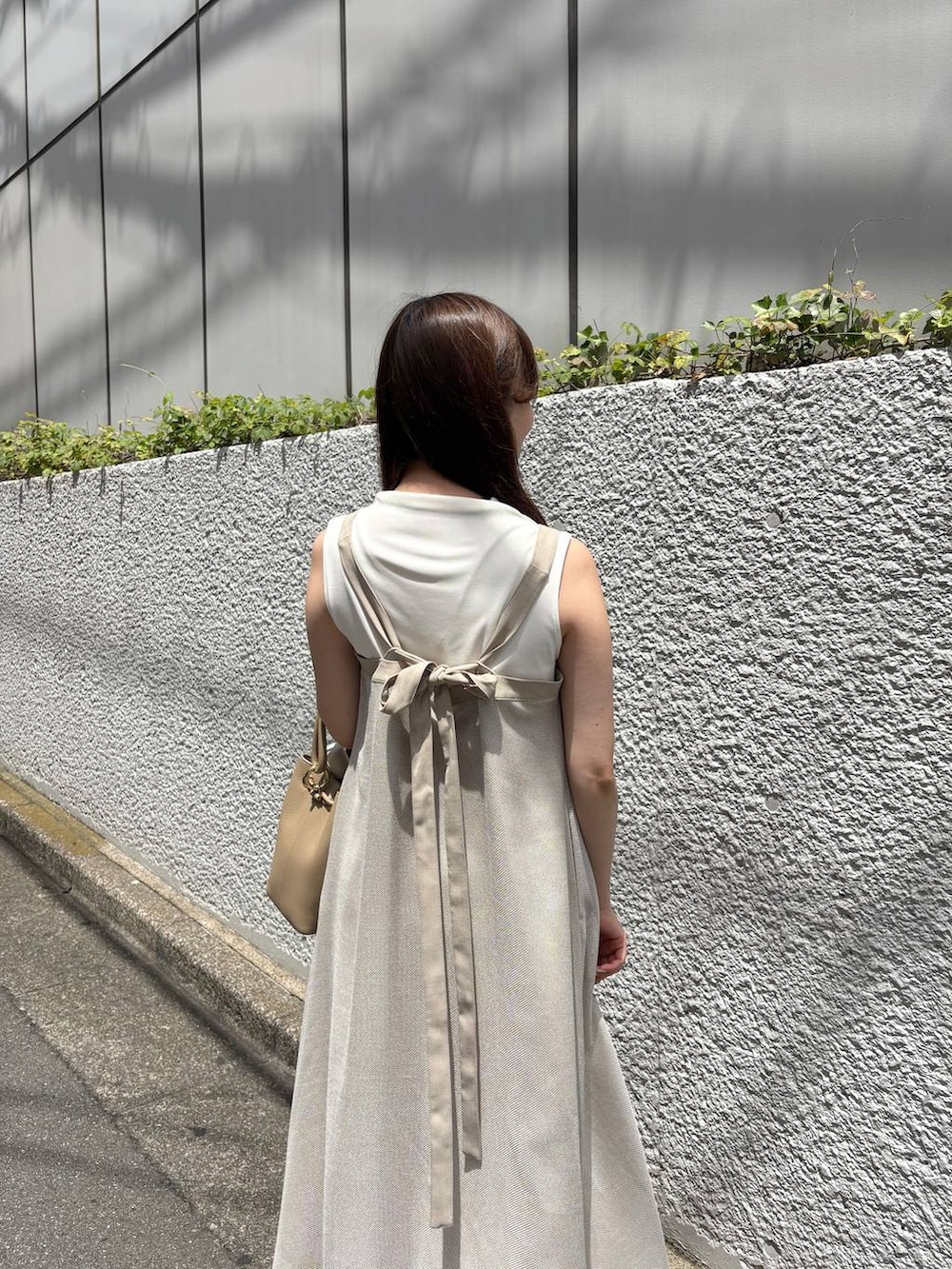 ベージュ系のワンピース、ホワイト系のTシャツ/カットソーを着用したレディースの夏コーディネートの2枚目の写真