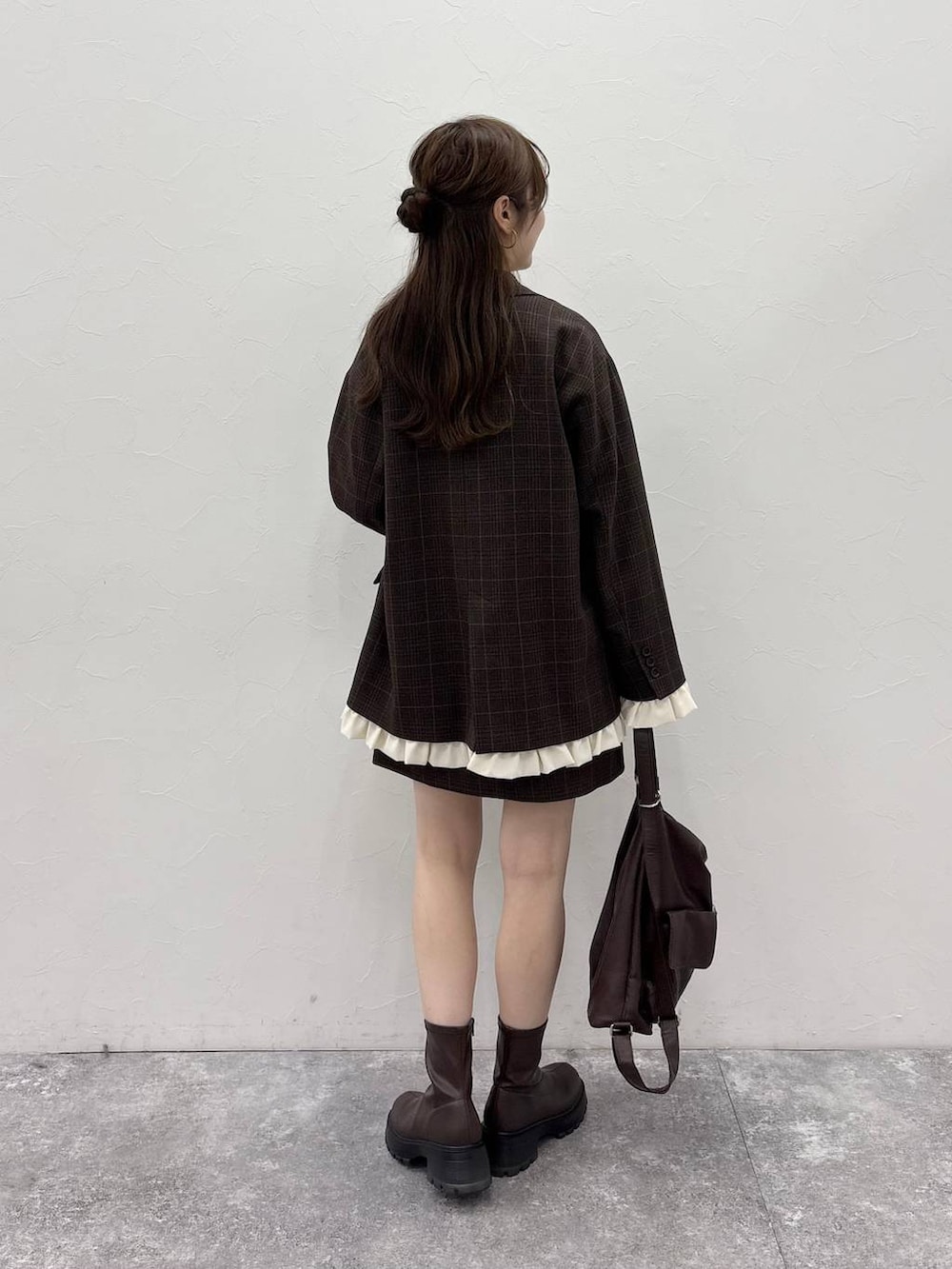 ブラウン系のブーツ、ブラウン系のバックパック/リュック、ホワイト系のTシャツ/カットソーを着用したレディースの秋コーディネートの3枚目の写真
