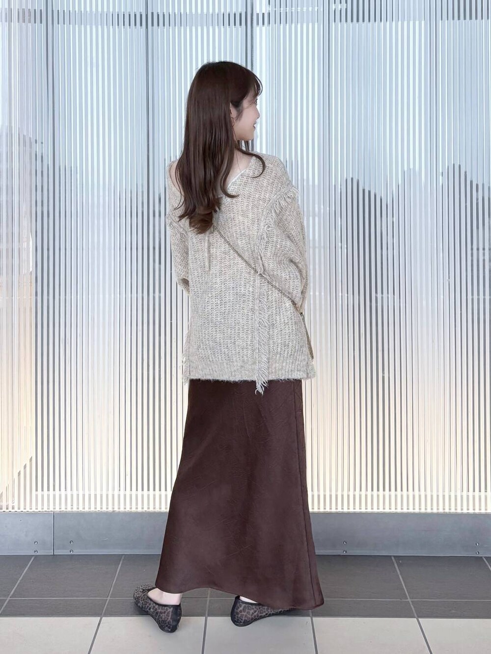 ゴールド系のショルダーバッグ、ホワイト系のニット/セーター、その他のバレエシューズを着用したレディースの夏コーディネートの4枚目の写真