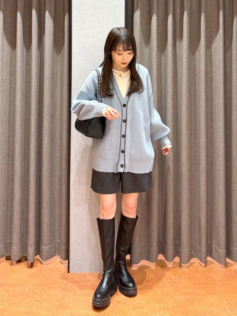 ブルー系のカーディガン/ボレロ、グレー系のその他パンツ、ブラック系のブーツを着用したレディースの冬コーディネートの2枚目の写真