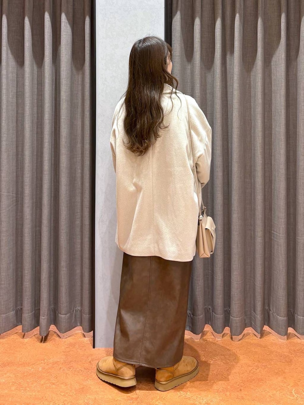 ホワイト系のニット/セーター、ホワイト系のその他アウター、ブラウン系のスカートを着用したレディースの冬コーディネートの3枚目の写真