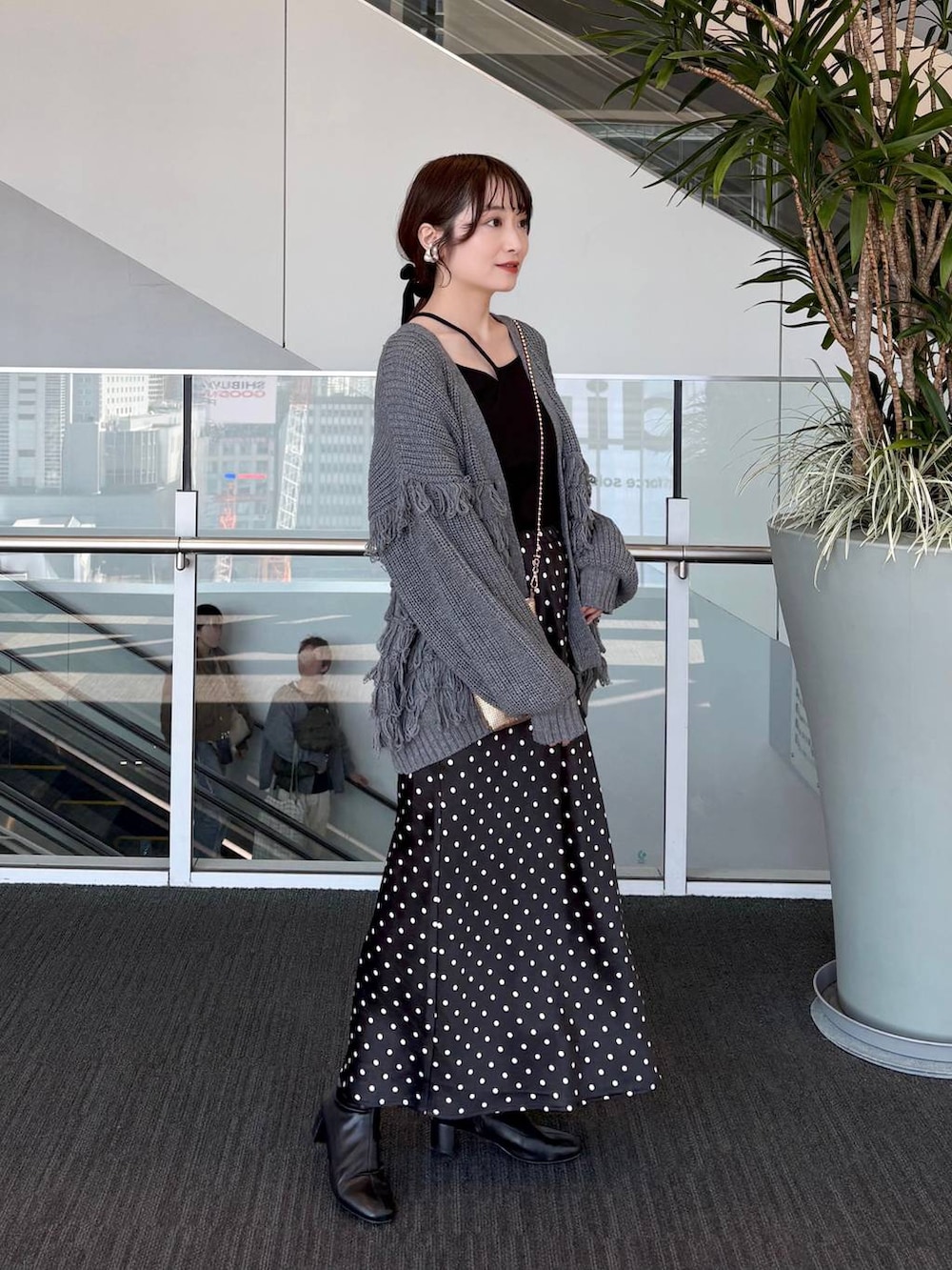 ゴールド系のショルダーバッグ、ブラック系のスカートを着用したレディースの春コーディネートの7枚目の写真