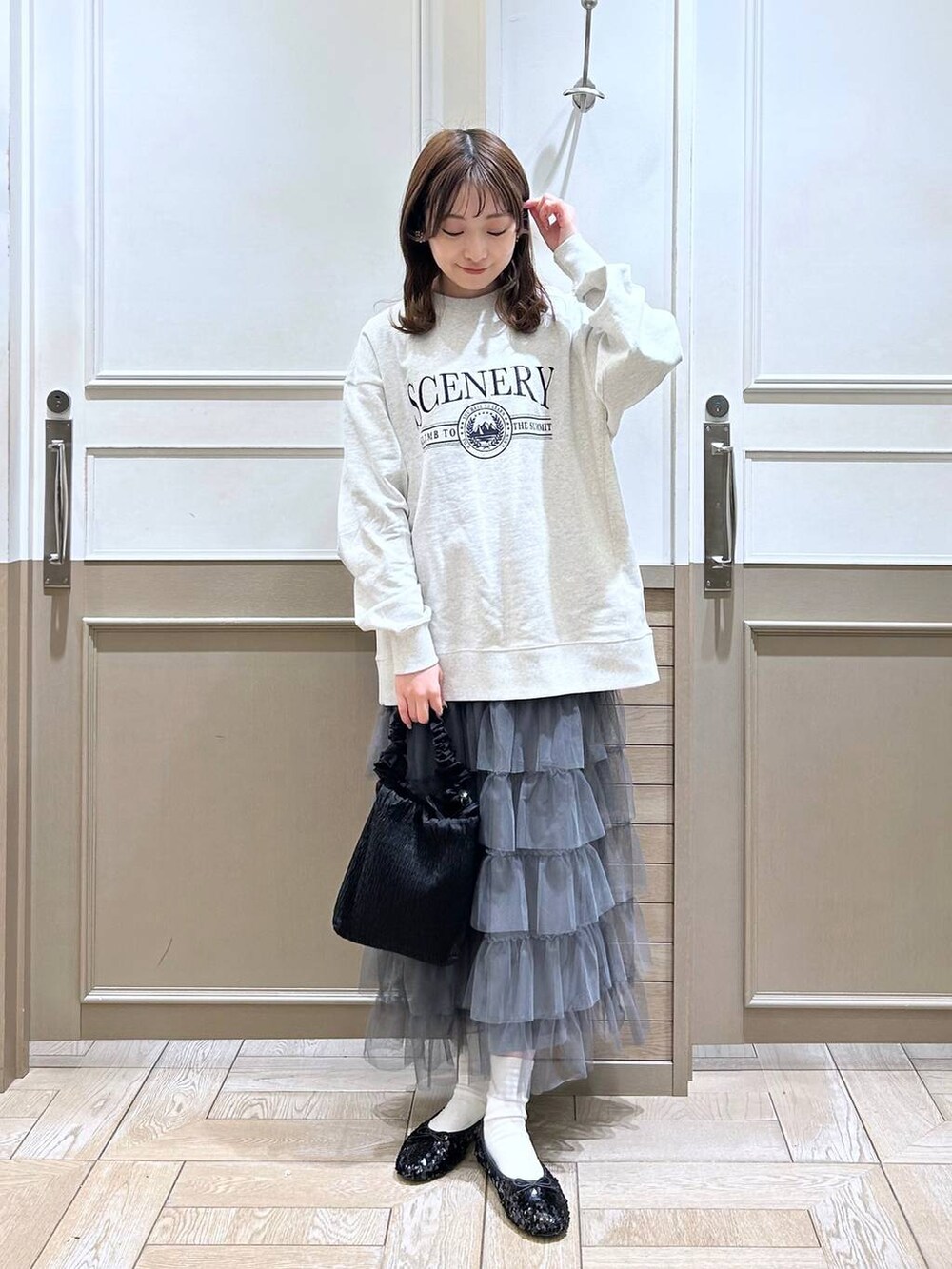 ブラック系のショルダーバッグ、グレー系のスカート、グレー系のスウェットを着用したレディースの冬コーディネートの2枚目の写真