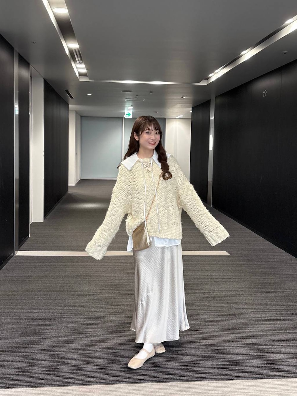 ゴールド系のショルダーバッグ、ホワイト系のニット/セーター、ホワイト系のシャツ/ブラウスを着用したレディースの秋コーディネートの2枚目の写真