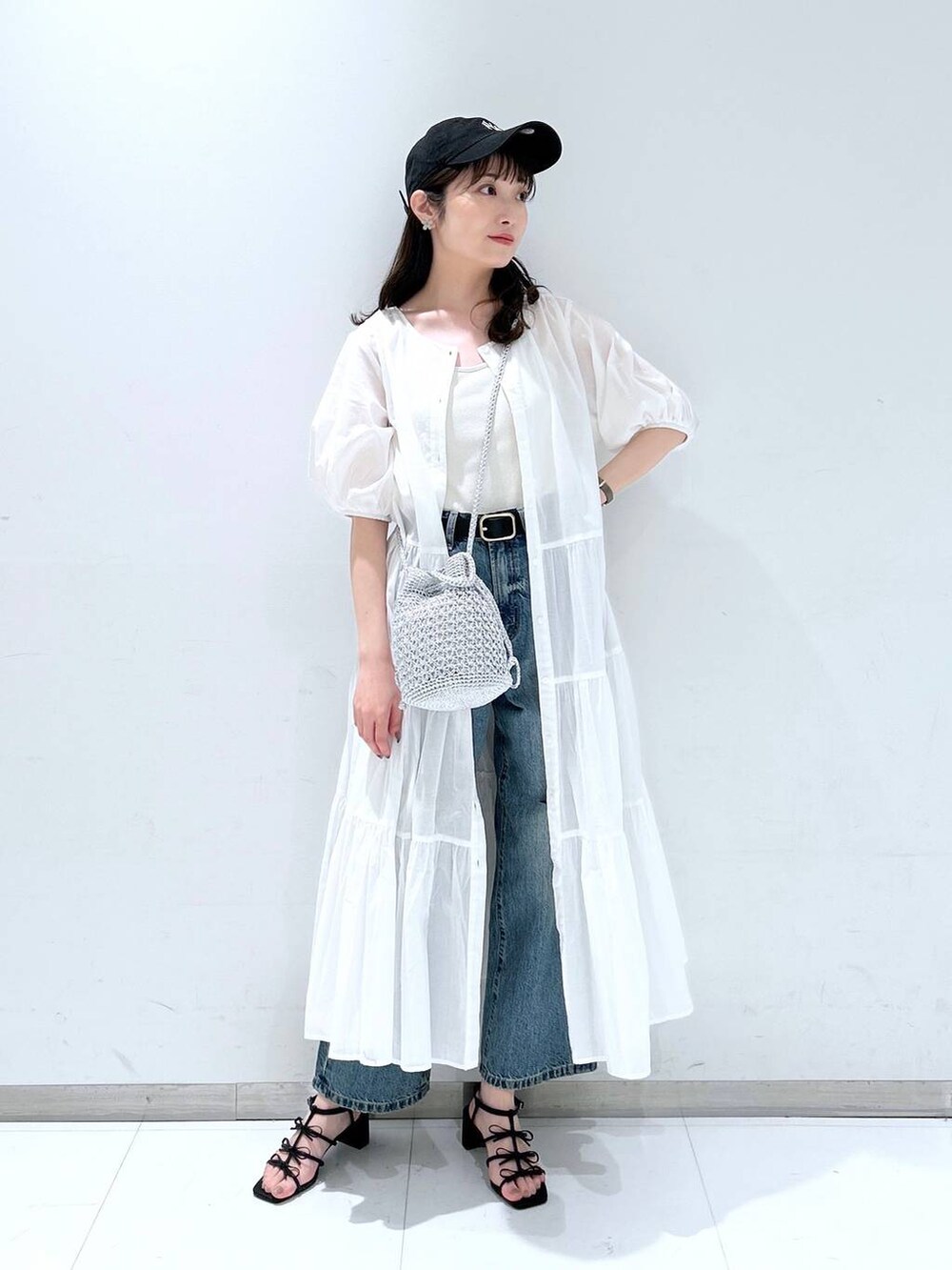 ホワイト系のTシャツ/カットソー、ブラック系のサンダル、ブルー系のデニムパンツを着用したレディースの春コーディネートの3枚目の写真