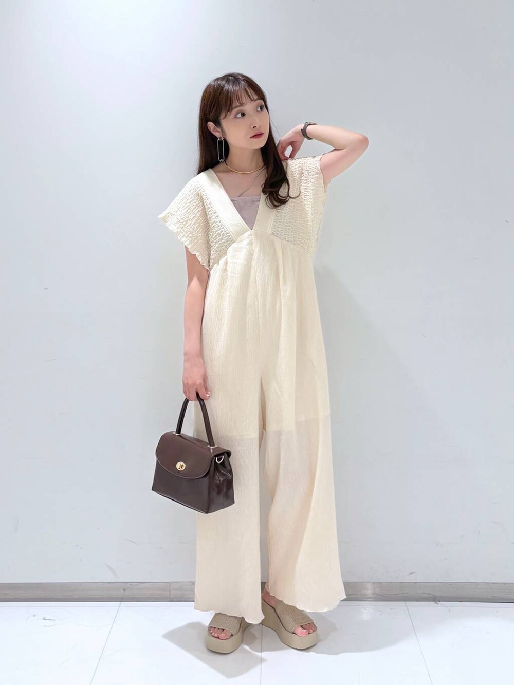 ホワイト系のサンダル、ホワイト系のサロペット/オーバーオール、ブラウン系のボストンバッグを着用したレディースの夏コーディネートの3枚目の写真