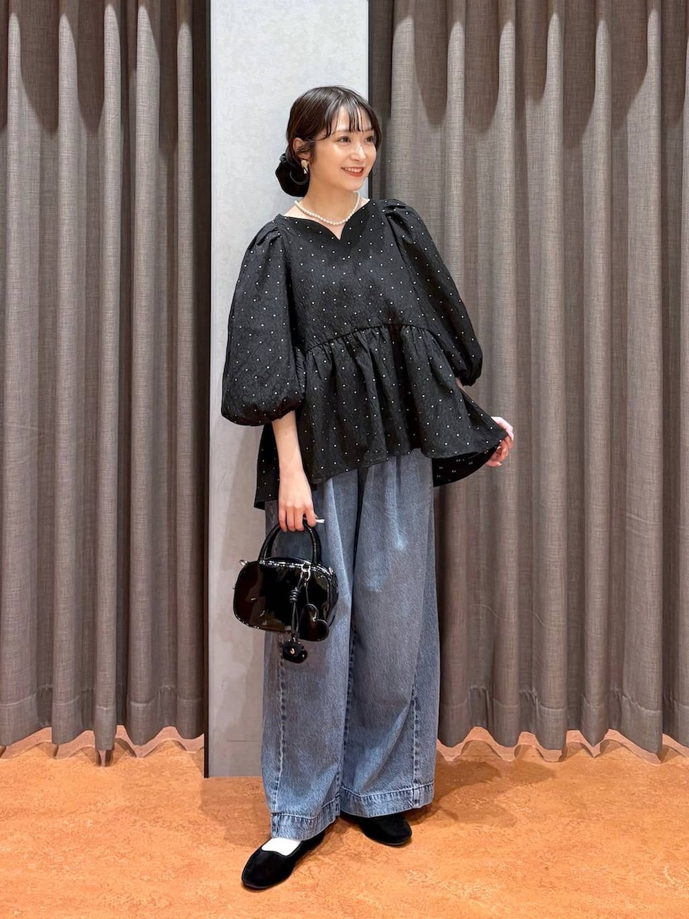 ブラック系のボストンバッグ、ブラック系のシャツ/ブラウス、ブルー系のデニムパンツを着用したレディースの冬コーディネートの2枚目の写真