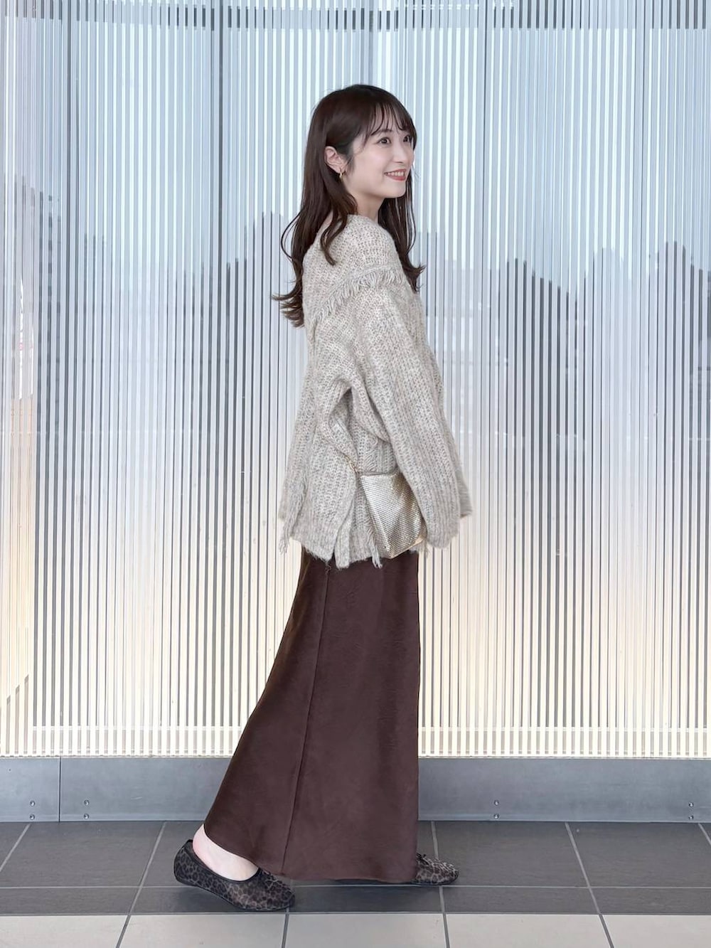 ゴールド系のショルダーバッグ、ホワイト系のニット/セーター、その他のバレエシューズを着用したレディースの夏コーディネートの3枚目の写真