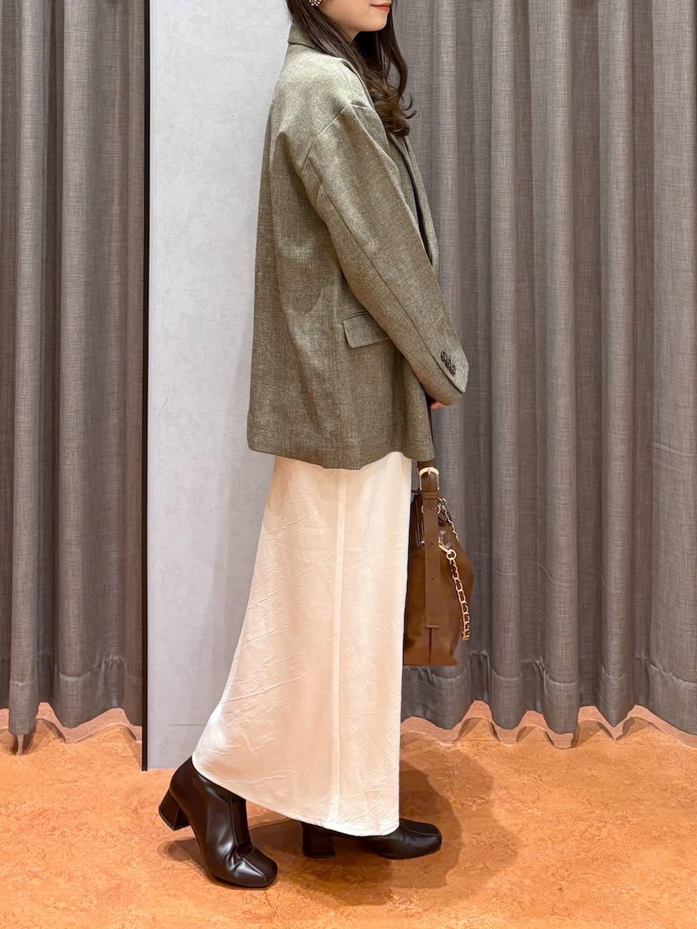 ホワイト系のスカート、ブラウン系のテーラードジャケット、ブラウン系のニット/セーターを着用したレディースの冬コーディネートの4枚目の写真