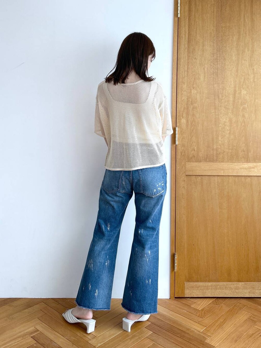 ホワイト系のタンクトップ、その他のデニムパンツ、ホワイト系のサンダルを着用したレディースの秋コーディネートの4枚目の写真