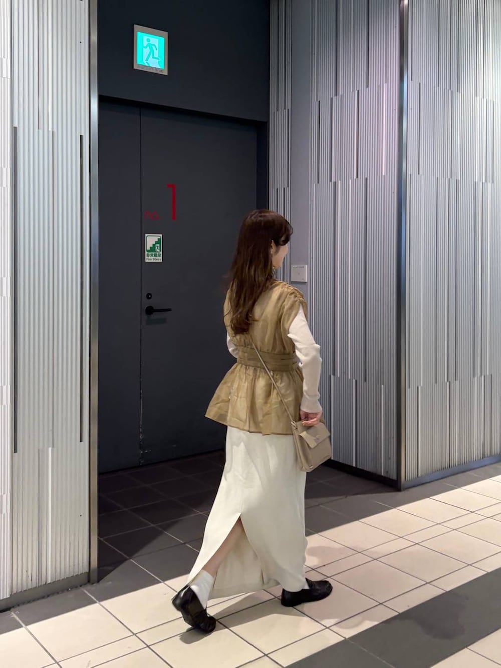 ブラウン系のローファー、ゴールド系のチョーカーを着用したレディースの冬コーディネートの7枚目の写真