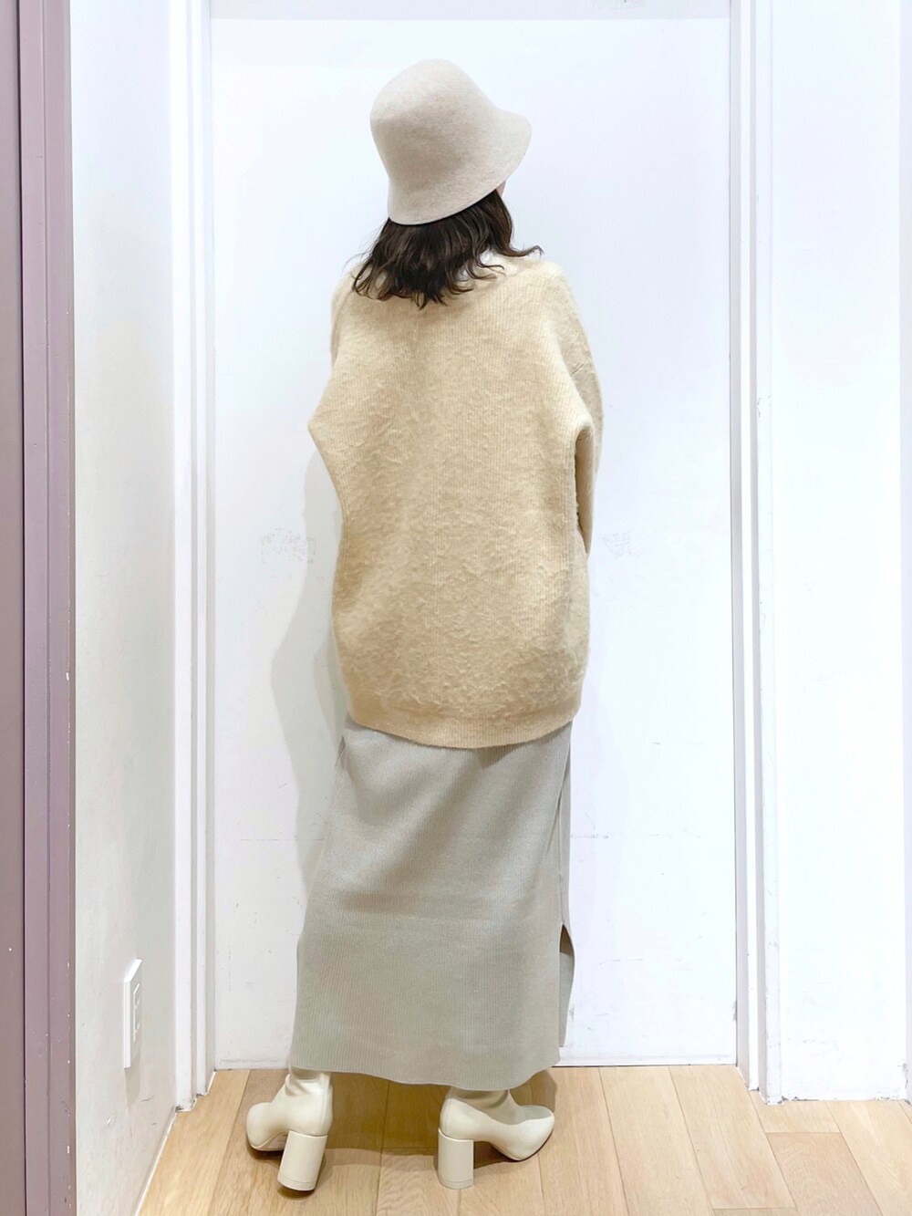 ホワイト系のワンピース、ベージュ系のカーディガン/ボレロ、ホワイト系のニット/セーターを着用したレディースの冬コーディネートの2枚目の写真