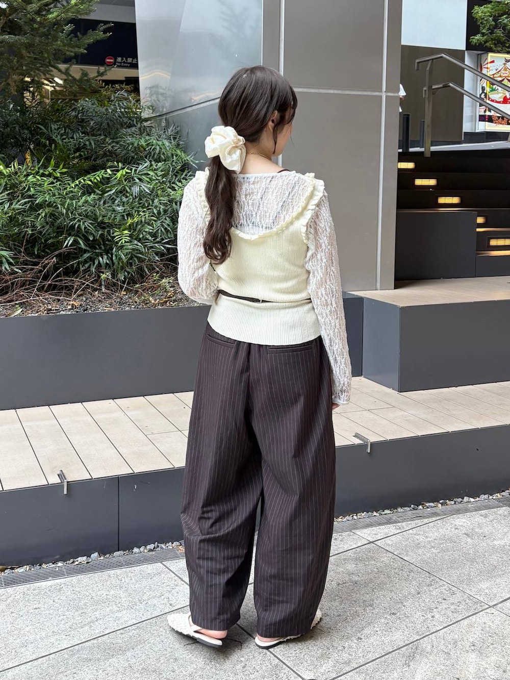 ブラウン系のその他パンツ、ホワイト系のタンクトップ、ブラウン系のボディバッグ/ウエストポーチを着用したレディースの春コーディネートの4枚目の写真