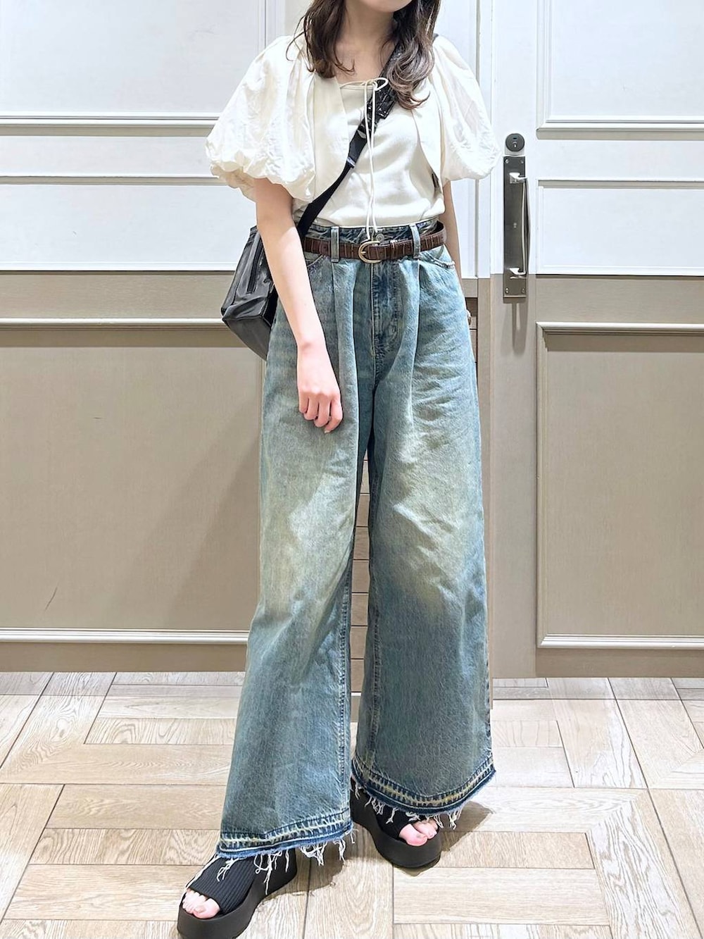 ホワイト系のTシャツ/カットソー、ブラック系のサンダル、ブルー系のデニムパンツを着用したレディースの春コーディネートの5枚目の写真