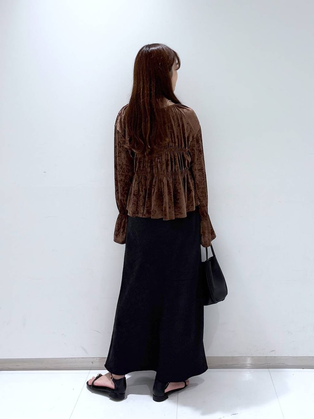 ブラック系のスカート、ブラック系のサンダル、ブラック系のショルダーバッグを着用したレディースの夏コーディネートの5枚目の写真