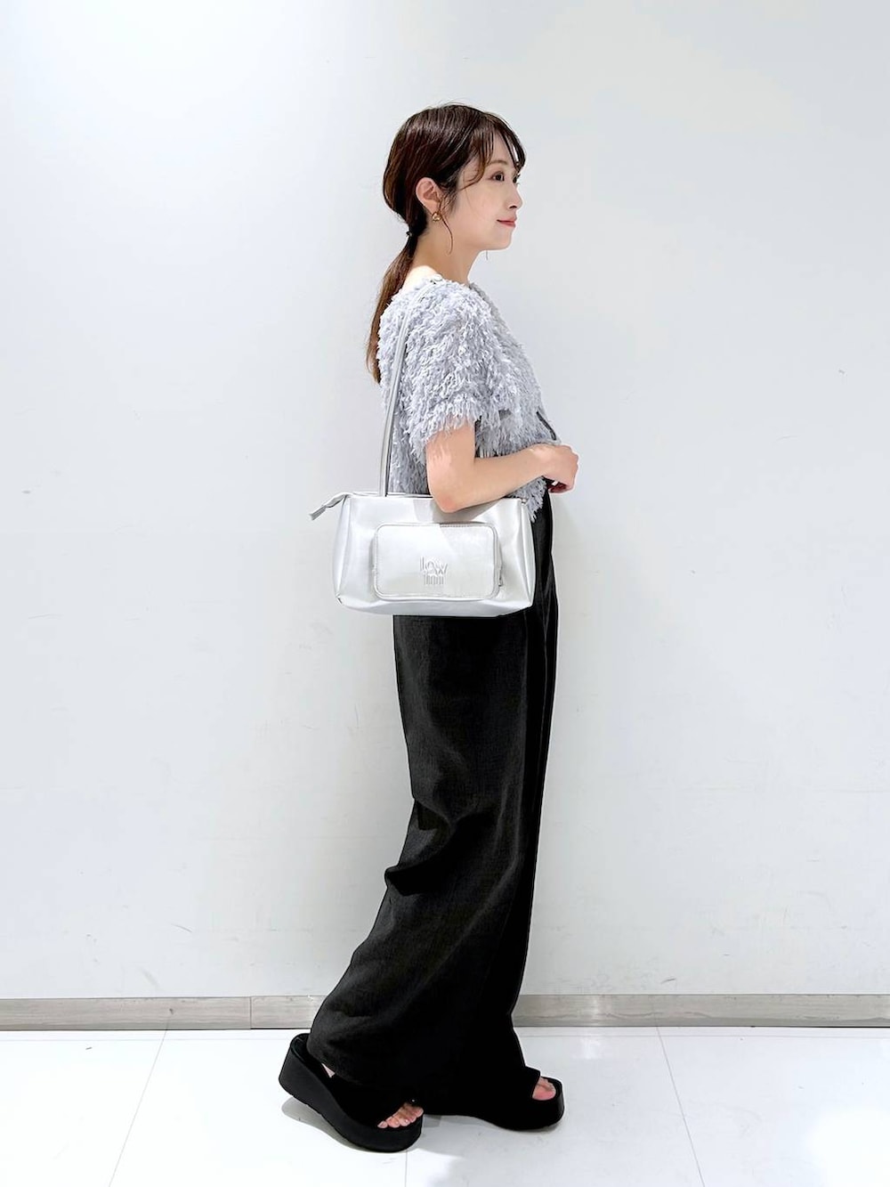 ブラック系のサンダル、ホワイト系のキャミソール、グレー系のスラックスを着用したレディースの夏コーディネートの4枚目の写真