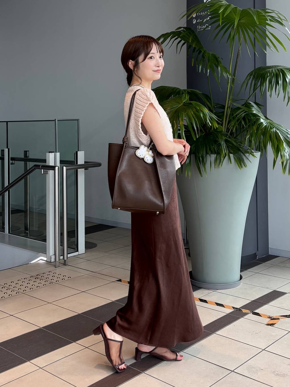 ブラウン系のスカート、ブラウン系のトートバッグ、ブラウン系のサンダルを着用したレディースの夏コーディネートの5枚目の写真