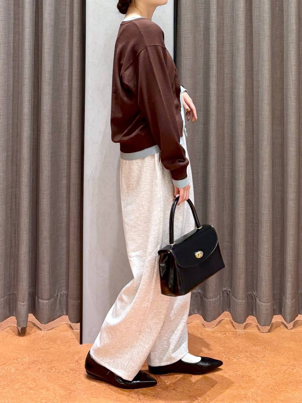 グレー系のスウェットパンツ、ブラック系のボストンバッグ、ブラック系のパンプスを着用したレディースの秋コーディネートの3枚目の写真