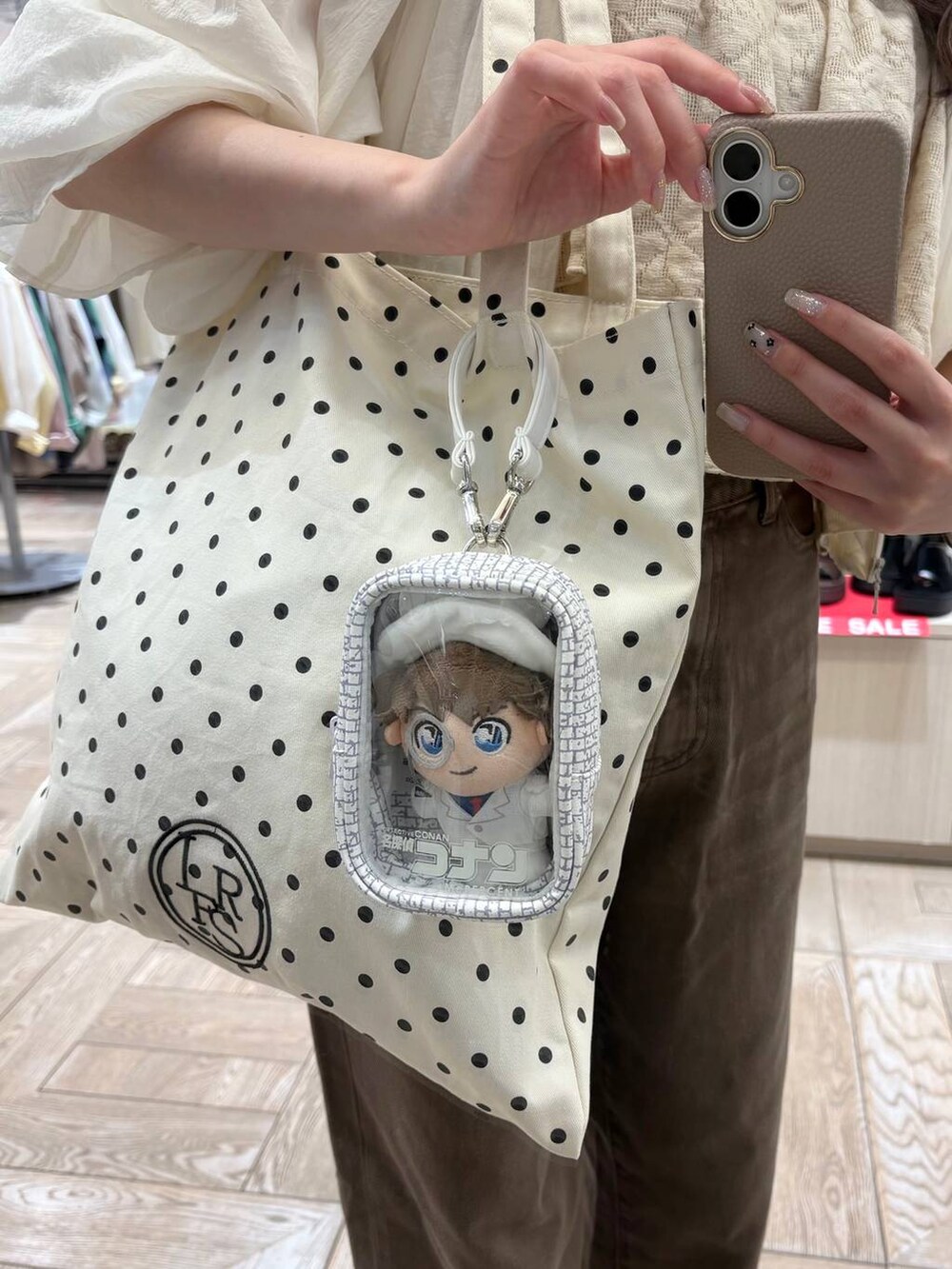 その他のトートバッグ、ブラウン系のデニムパンツ、ホワイト系のブルゾンを着用したレディースの夏コーディネートの2枚目の写真