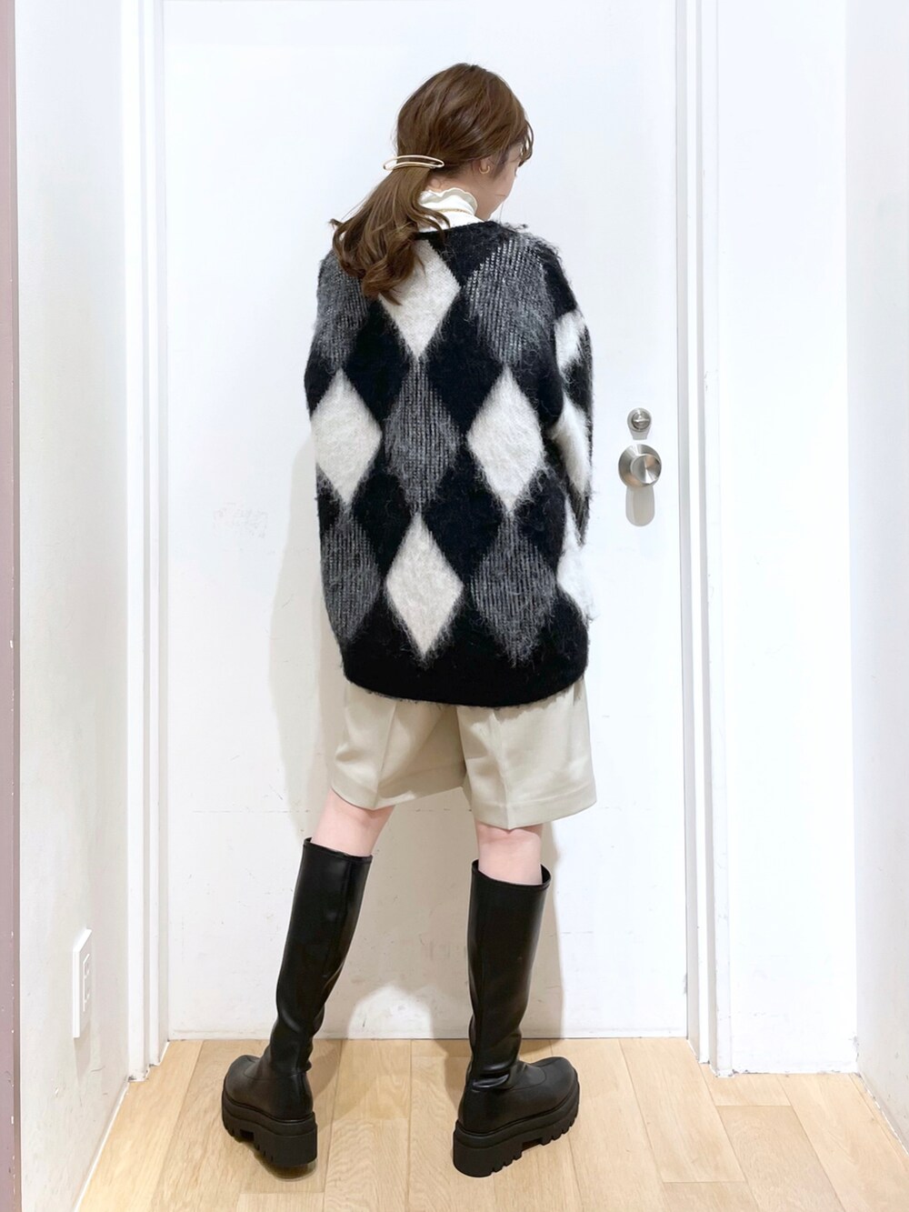 ブラック系のブーツ、ホワイト系のパンツ、ブルー系のショルダーバッグを着用したレディースの秋コーディネートの2枚目の写真
