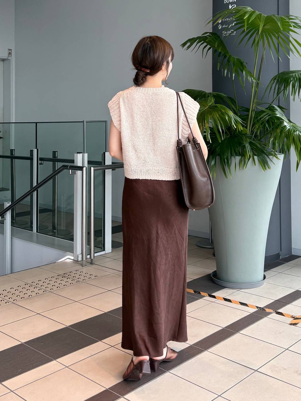 ブラウン系のスカート、ブラウン系のトートバッグ、ブラウン系のサンダルを着用したレディースの夏コーディネートの6枚目の写真