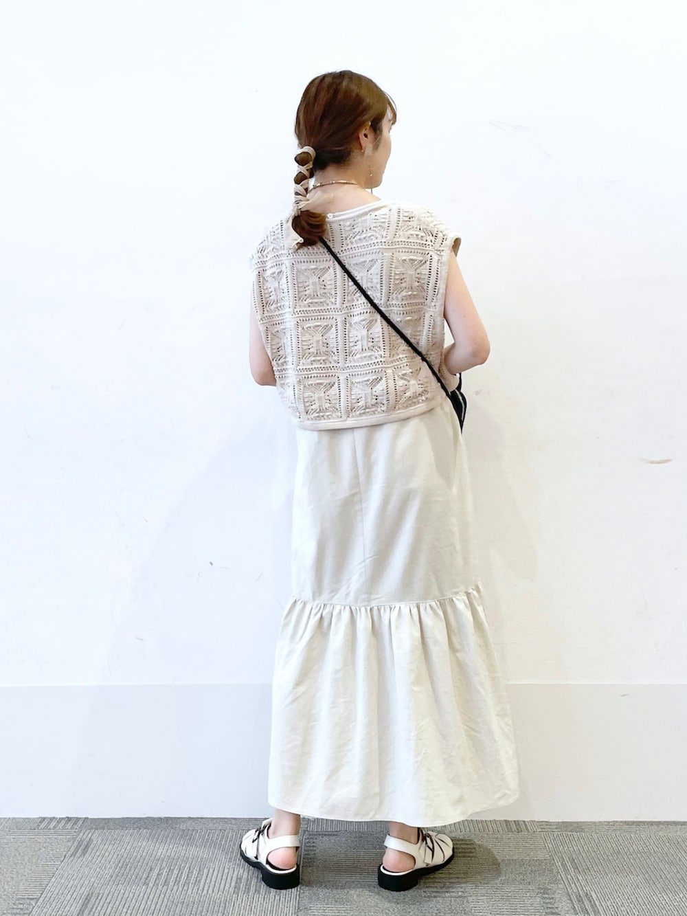 ホワイト系のサンダル、ホワイト系のワンピース、ブラック系のショルダーバッグを着用したレディースの夏コーディネートの2枚目の写真