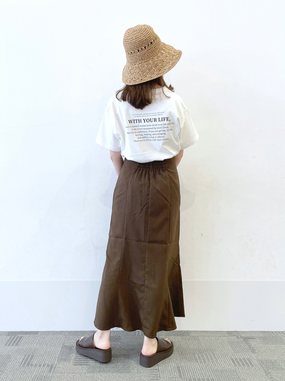 ブラック系のショルダーバッグ、ブラウン系のサンダル、ブラウン系のスカートを着用したレディースの夏コーディネートの2枚目の写真