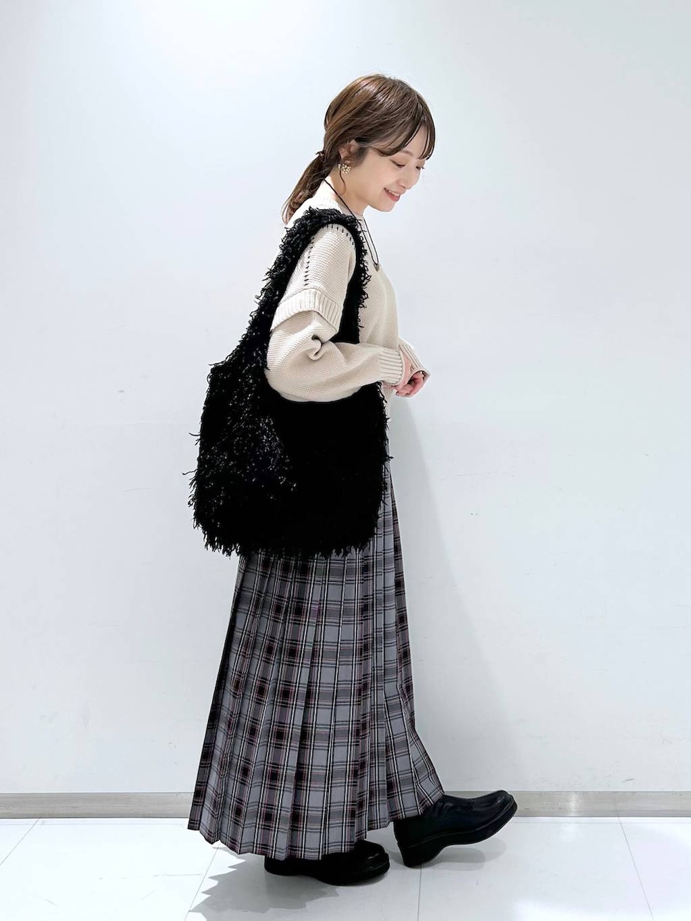 ホワイト系のTシャツ/カットソー、ブラック系のブーツ、ブラック系のトートバッグを着用したレディースの冬コーディネートの3枚目の写真