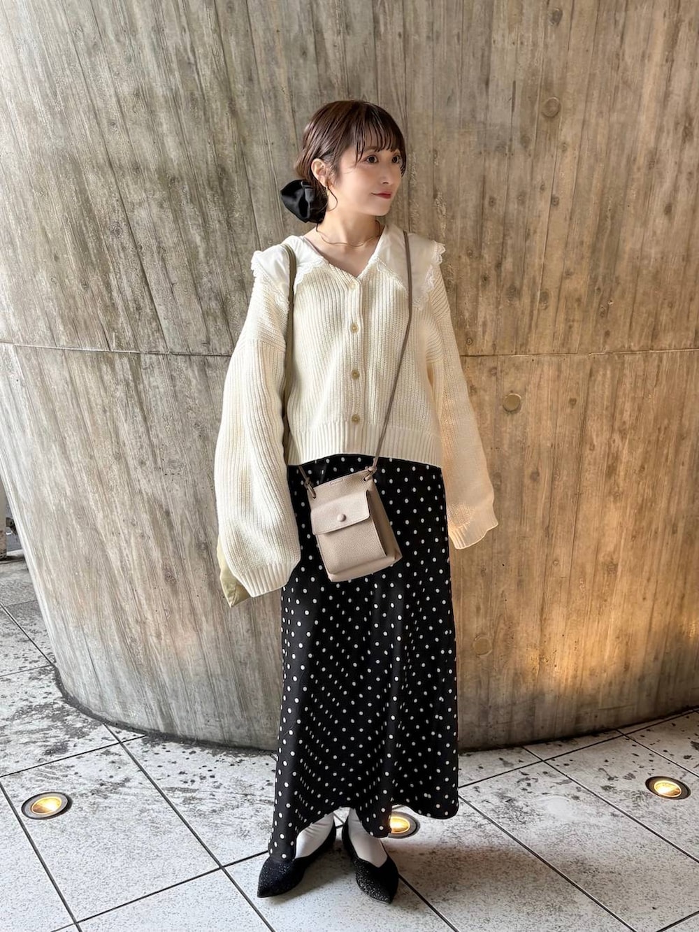 ブラック系のスカート、ブラック系のパンプス、ホワイト系のカーディガン/ボレロを着用したレディースの冬コーディネートの3枚目の写真