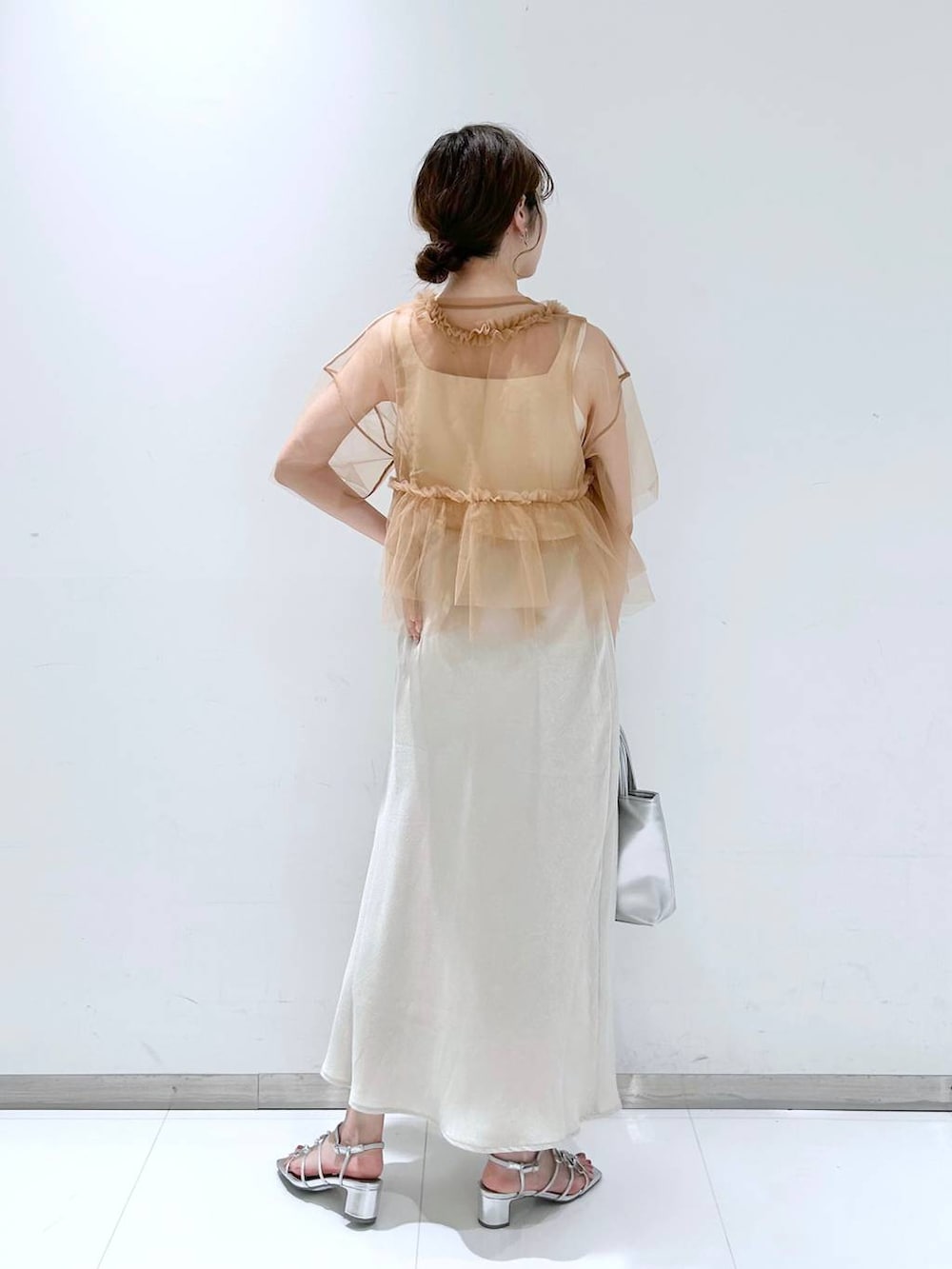 シルバー系のサンダル、ホワイト系のタンクトップ、ホワイト系のスカートを着用したレディースの夏コーディネートの5枚目の写真